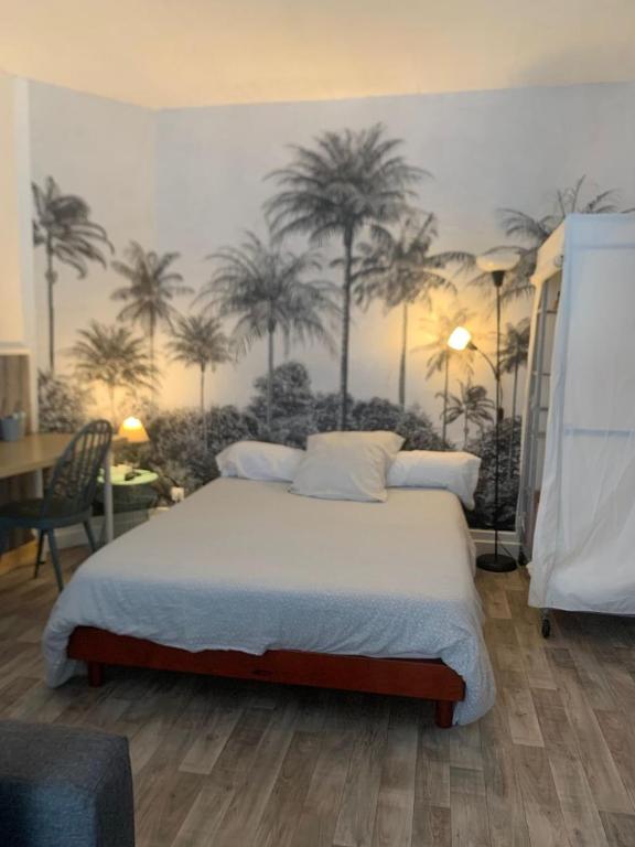 - une chambre avec un lit recouvert de palmiers dans l'établissement Votre pied à terre à proximité des dunes, à Berck-sur-Mer