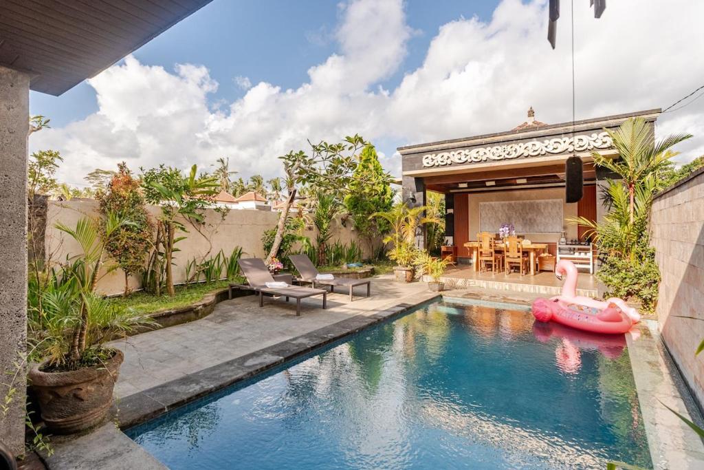Una piscina con un bote inflable rosa en un patio trasero. en Private 2BR Villa Pool, Gym, BBQ, en Ubud