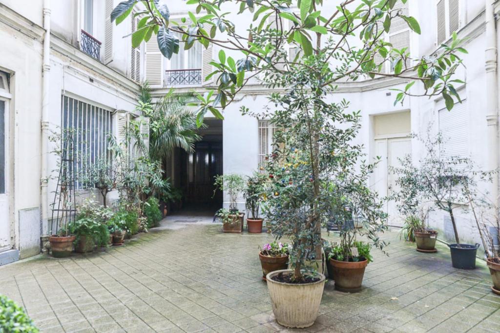 une cour d'un bâtiment avec des plantes en pot dans l'établissement Nice Studio Near Eiffel Tower, à Paris