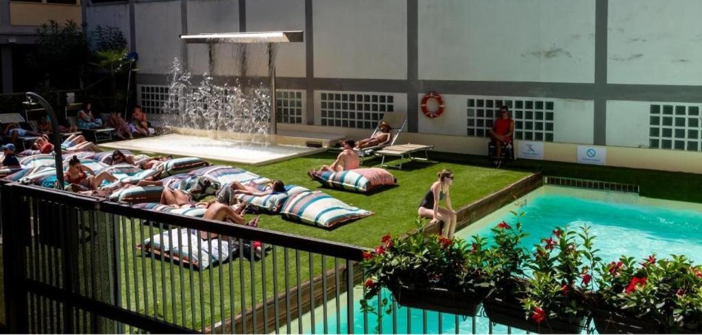 a group of people laying around a swimming pool at Plus Florence in Florence