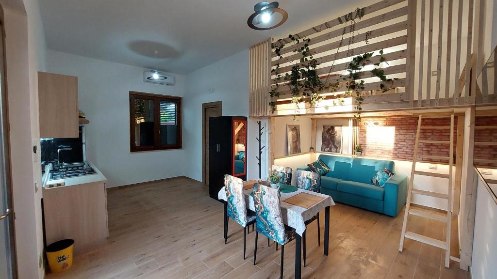 a living room with a blue couch and a table at Rosa Room in Castelnuovo Cilento
