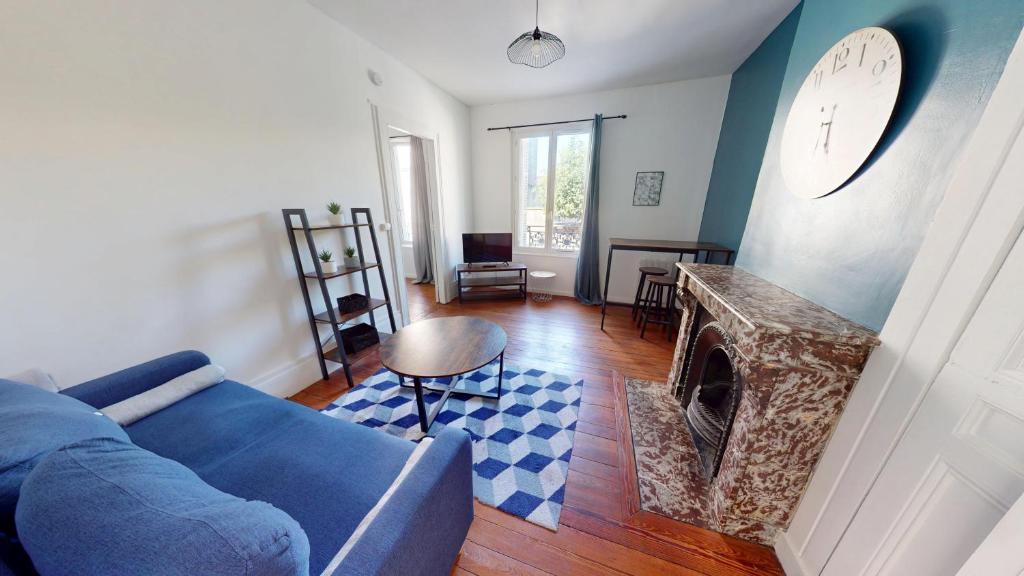 un salon avec un canapé bleu et une cheminée dans l'établissement Bougainville - T2 Comfort & Quiet & Train Station, au Havre