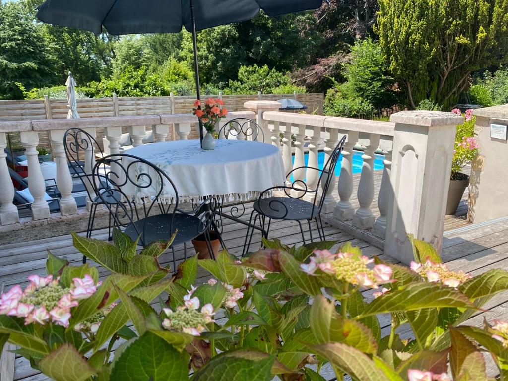 a table and chairs with an umbrella on a balcony at Maison de l'Aumance in Meaulne