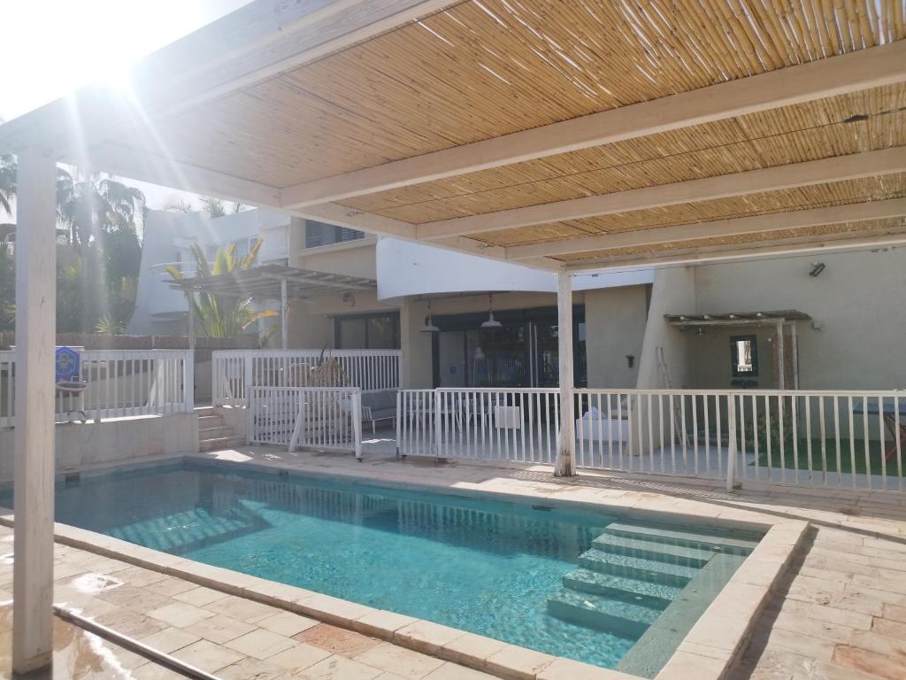 a swimming pool under a pergola at YalaRent Cliff side villa with private pool in Eilat