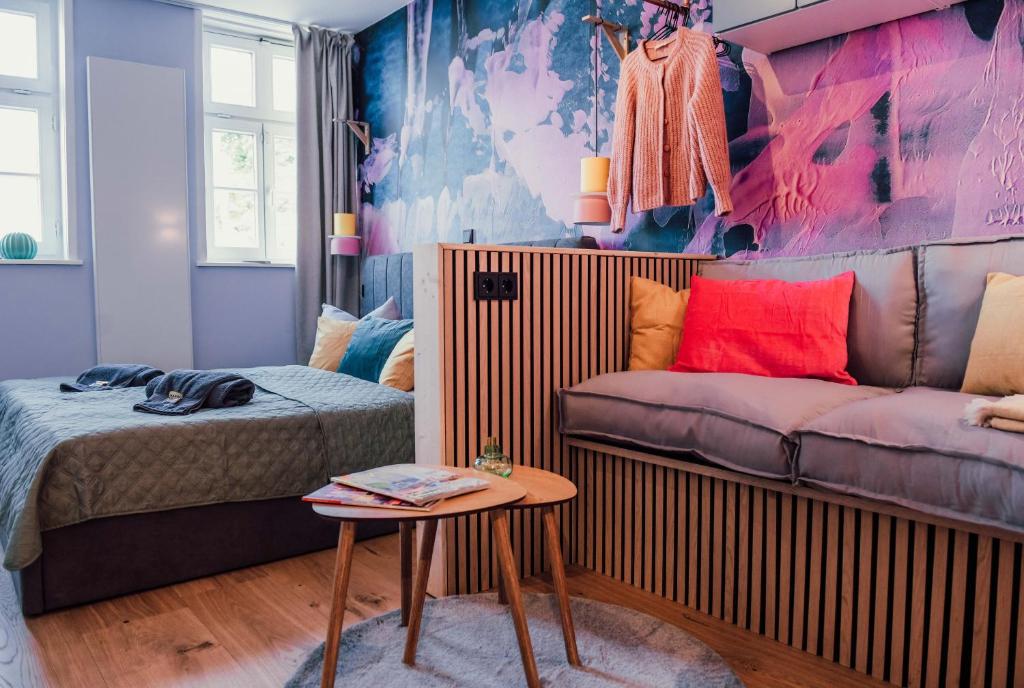 a bedroom with a bed and a couch and a table at sleepArt atelier in Celle