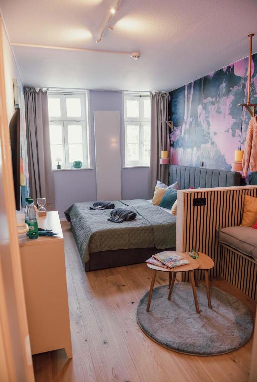 a bedroom with a bed and a table and a couch at sleepArt atelier in Celle