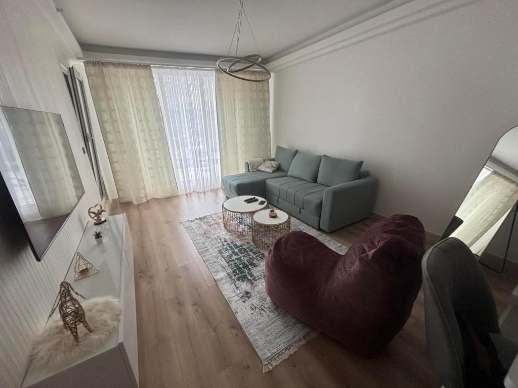 a living room with a couch and a chair at The Sky View Apartments in Skopje