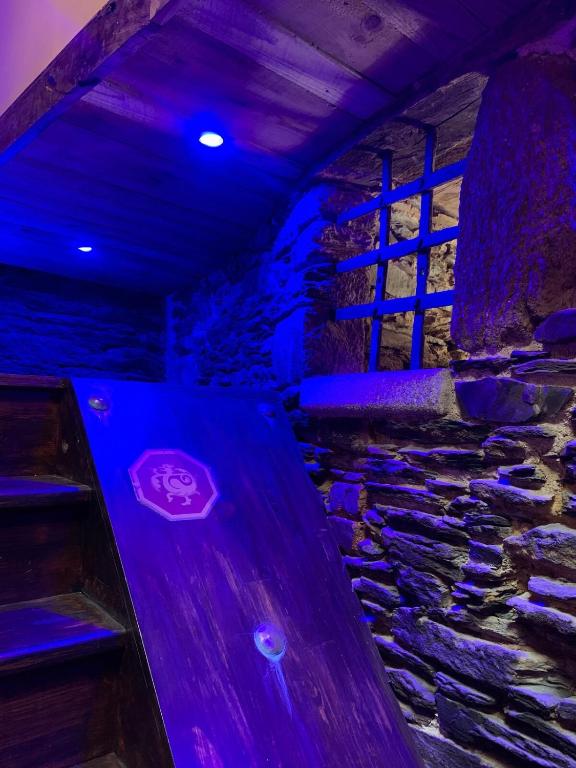 Cette chambre dispose d'un banc en bois et d'un mur en pierre. dans l'établissement Séjournez dans la Tour !, à Ploërmel