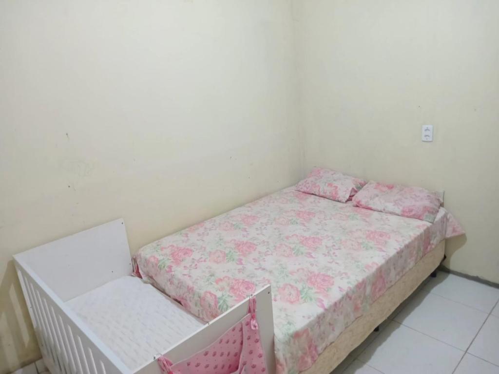 a small bedroom with a bed and a chair at Hospedaria lençóis em santo amaro MA in Santo Amaro
