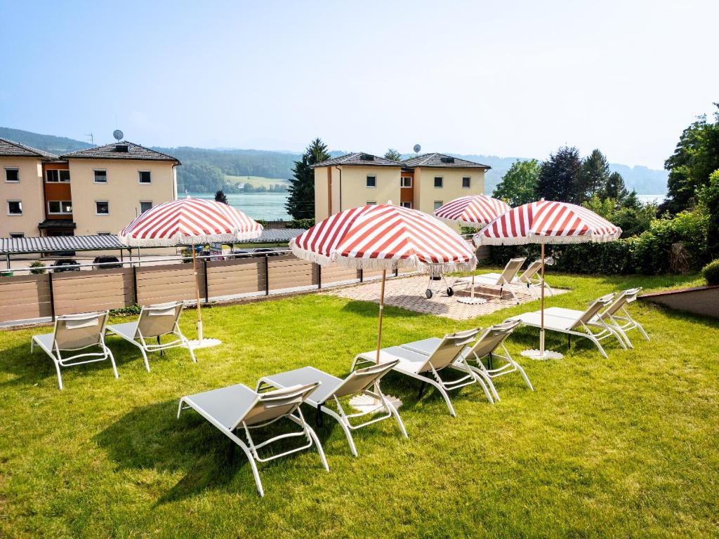 a group of chairs and umbrellas on the grass at Ferienwohnungen see punkt in Sekull