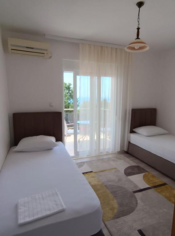 a bedroom with two beds and a view of a patio at Jasmin 4 in Ulcinj