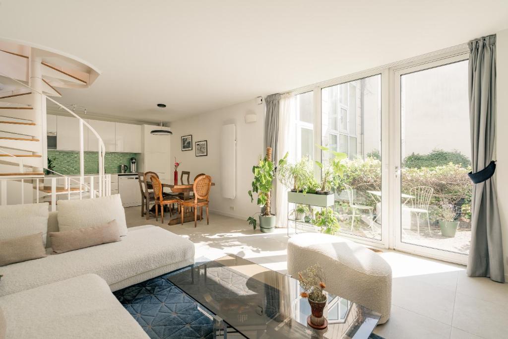 un salon avec un canapé et une table en verre dans l'établissement Veeve - Buttes Chaumont Maisonnette, à Paris