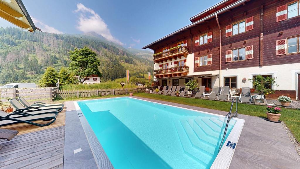 a house with a swimming pool next to a building at Hotel Schlosswirt in Großkirchheim