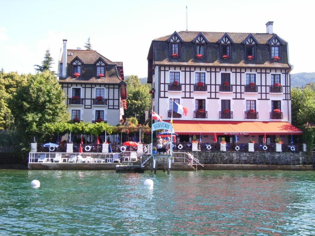 a couple of buildings sitting next to a body of water at Les Cygnes in Évian-les-Bains