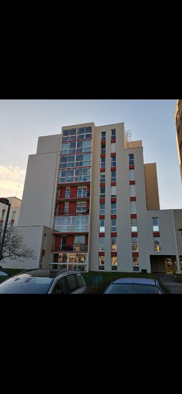 un grand bâtiment avec des voitures garées devant dans l'établissement Laetitia Touzé, à Rennes