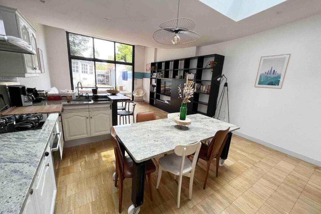 une cuisine et une salle à manger avec une table et des chaises dans l'établissement Maison Charmante - Centre de Ville - Proche gare, à La Roche-sur-Yon