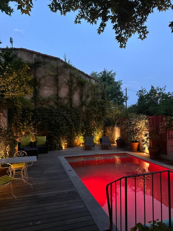 - une piscine avec éclairage rouge dans l'arrière-cour dans l'établissement Avignon Campagne, à Avignon
