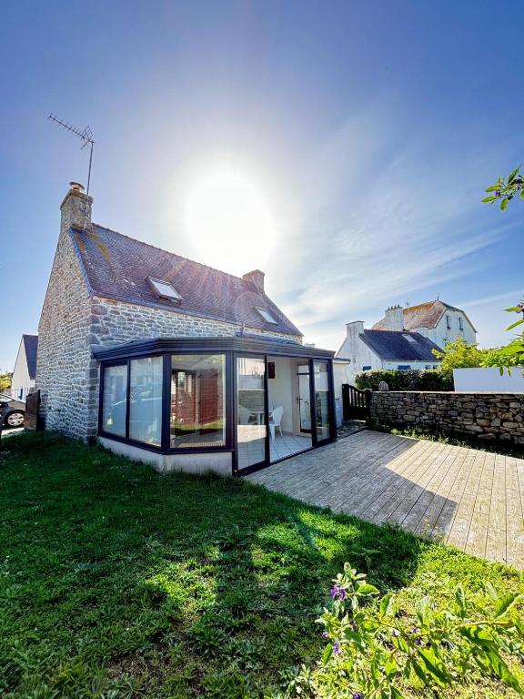 une extension vers une maison en briques avec une terrasse dans l'établissement Penty Bretagne, à Penmarcʼh