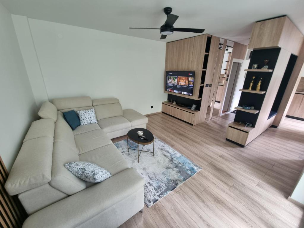 Una sala de estar con un sofá y un televisor. en Central Spot BL, en Banja Luka