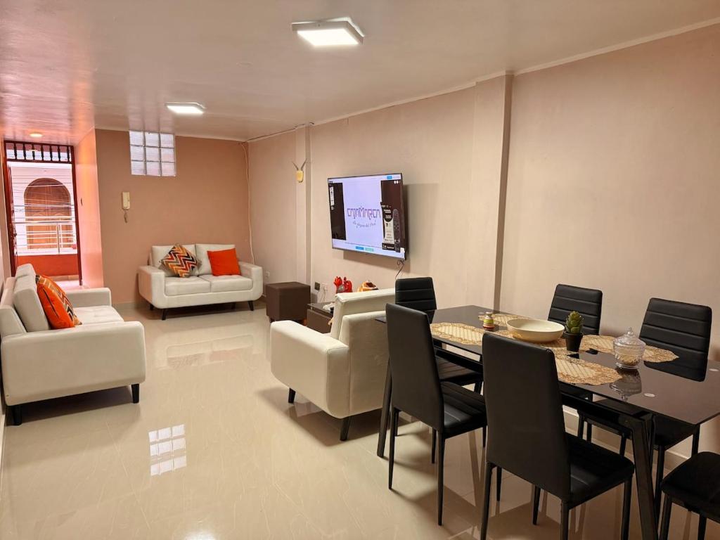 een woonkamer met een tafel, stoelen en een bank bij Jaichi KIREI in Cajamarca