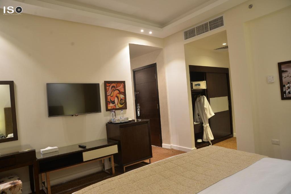 a bedroom with a bed and a tv and a mirror at Tolip El Narges in Cairo