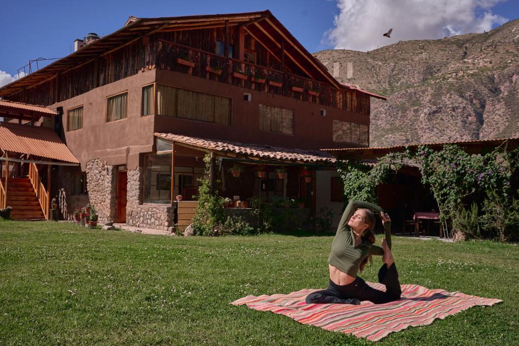 un uomo seduto su una coperta sull'erba di Piedra Wasi Ecolodge Urubamba a Urubamba