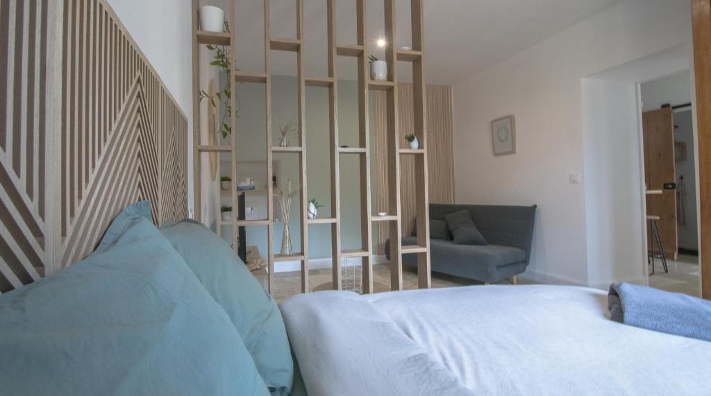 a bedroom with a bed and a couch and a chair at Le Clos Bertin in Néac