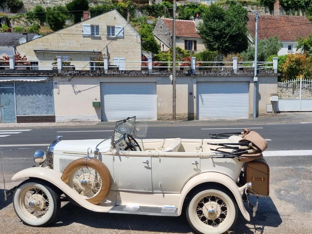 une vieille voiture garée sur le côté d'une rue dans l'établissement Appartement indépendant avec terrasse, à Bourré
