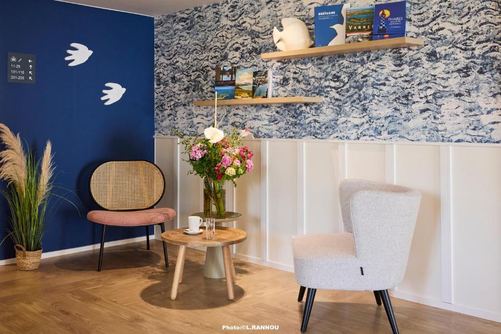 2 chaises et une table avec un vase de fleurs dans l'établissement Quality Hotel La Marebaudière Vannes Centre, à Vannes