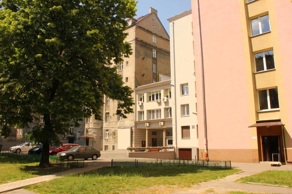 a group of buildings in a city with a tree at Central Warsaw Apartment in Warsaw