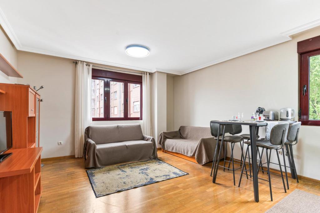 ein Wohnzimmer mit einem Tisch und einem Sofa in der Unterkunft Apartamento Avenida del Mar in Oviedo