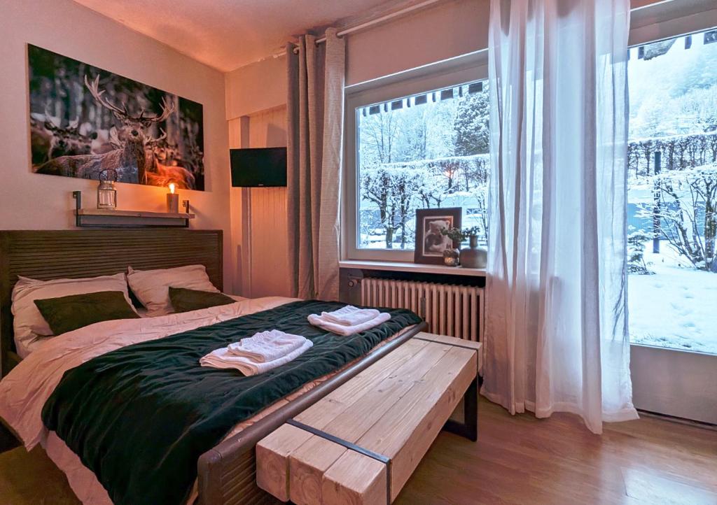 - une chambre avec un lit et un banc en bois à côté d'une fenêtre dans l'établissement Au Petit Bois, à Chamonix-Mont-Blanc