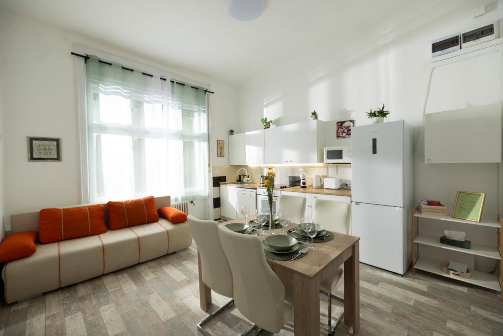 a kitchen and living room with a table and a couch at Elek Garden Apartman in Budapest