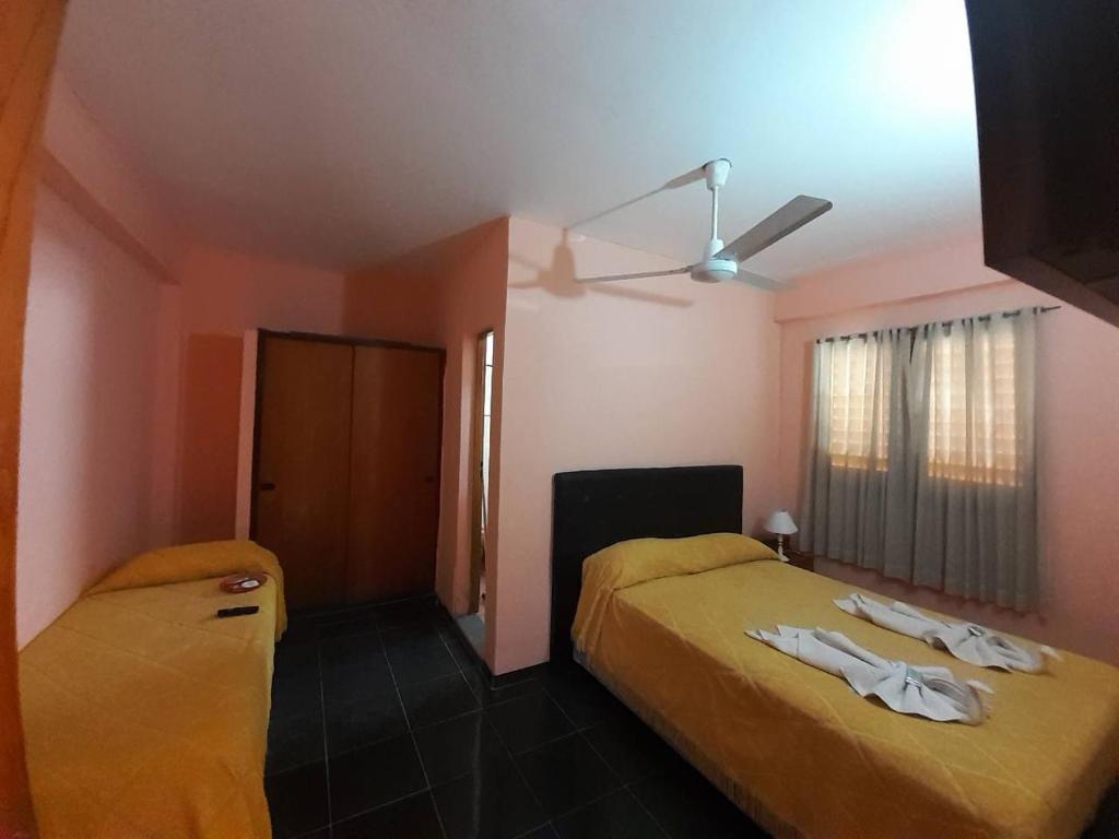 een slaapkamer met twee bedden en een plafondventilator bij Costa del sol Termas Ex Lucas III in Termas de Río Hondo
