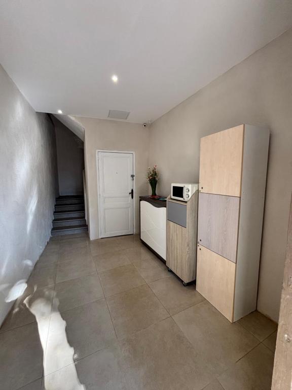 a kitchen with a refrigerator and a staircase at La Perle in Narbonne
