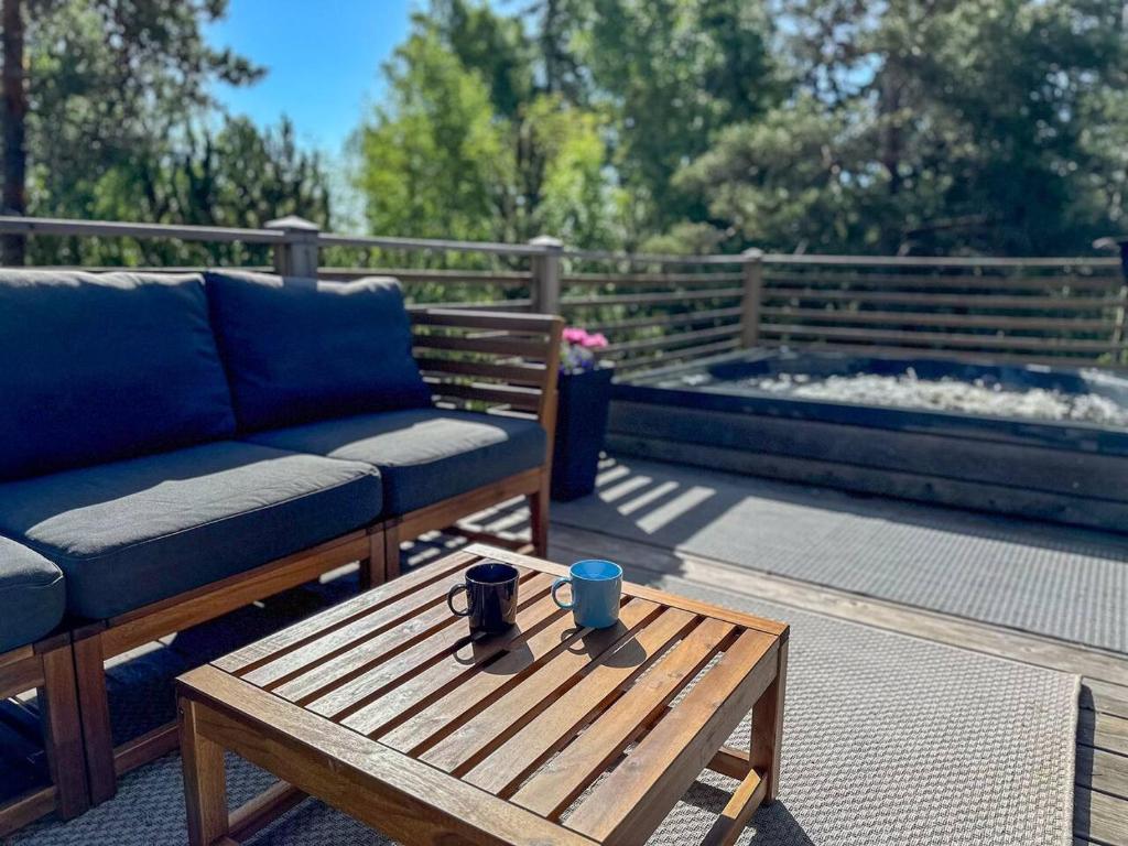 ein Sofa und einen Couchtisch auf einer Terrasse in der Unterkunft Villa Mustikka - Modern Log Villa on a Waterfront Estate in Långstrand