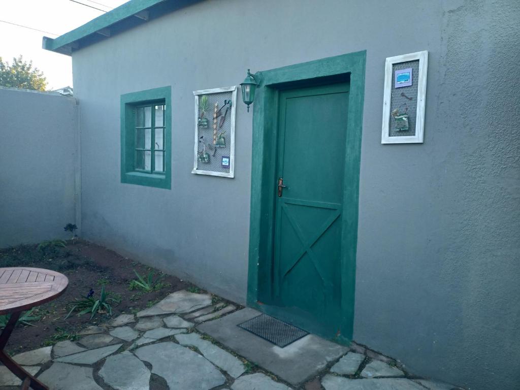una puerta verde en el costado de un edificio en Mooi Uitsig Droom, en Beaufort West