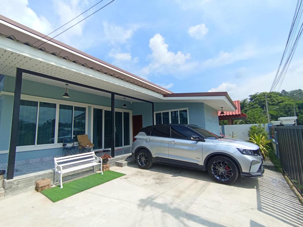 Un coche blanco aparcado delante de una casa en R-Rich Homestay อาริชโฮมสเตย์, en Betong