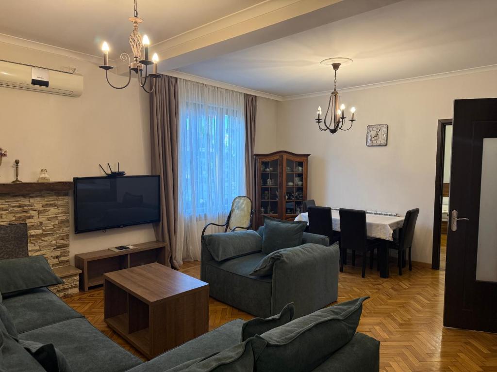 a living room with a couch and a television and a table at Kobuleti apartment in Kobuleti