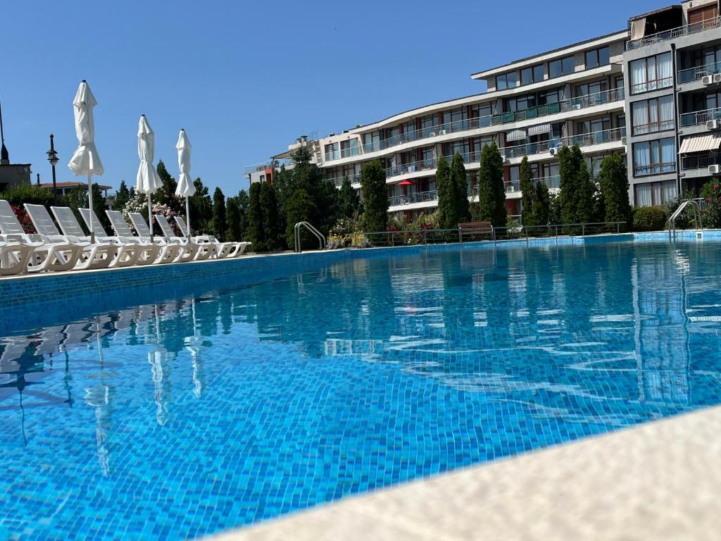 a large swimming pool in front of a building at Sun Wave Apartament in Sveti Vlas