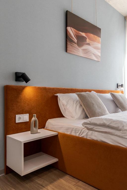 a bedroom with a bed and a night stand with a vase on it at Prime Rest Apartments in Lviv
