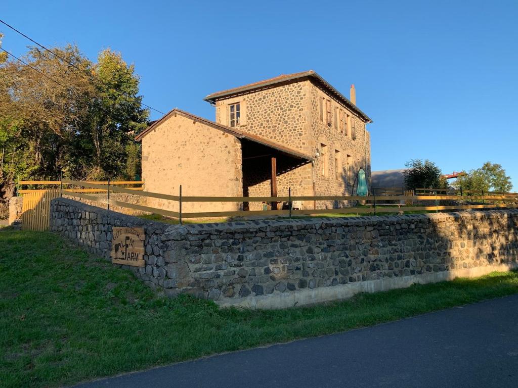 un mur en pierre devant un bâtiment dans l'établissement gite LFMFARM maison tout confort, à La Celle-sous-Gouzon