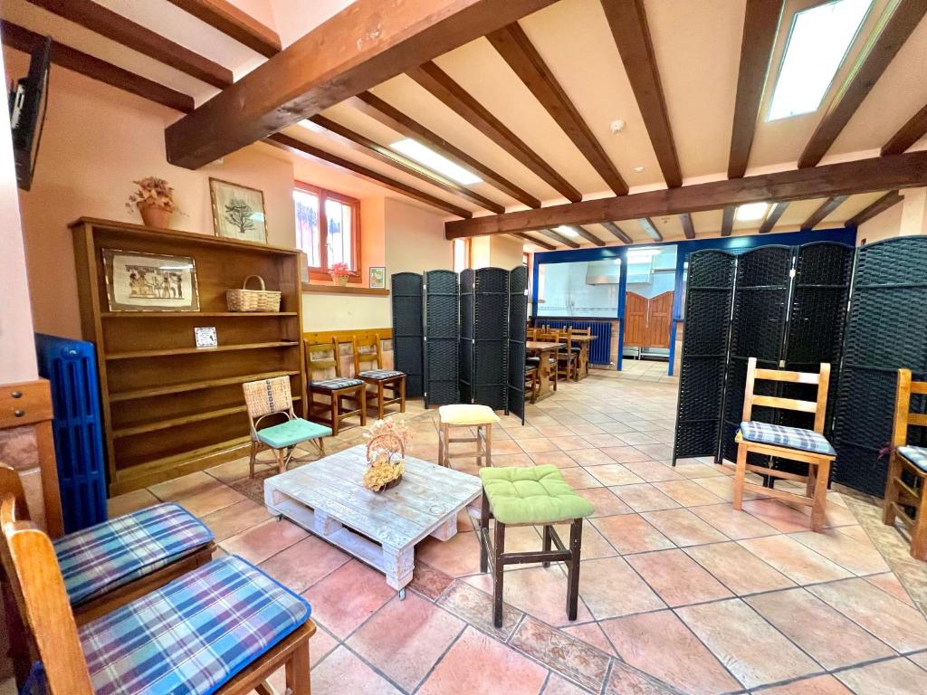 a room with chairs and a table and chairs at Albergue Urbasa in Eulate