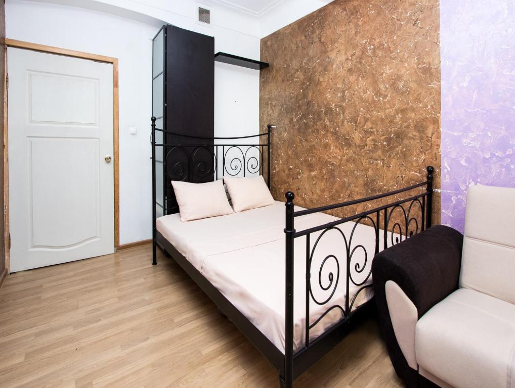 1 dormitorio con 1 cama negra y 1 silla en ApartLux Kremlyovskaya, en Moscú