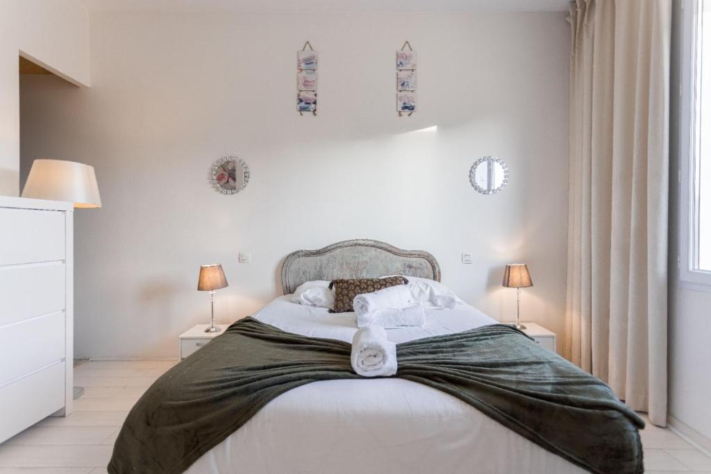 une chambre avec un grand lit avec des draps et des oreillers blancs dans l'établissement Duplex Jaurès - city center, AC, 10mn from Palais, à Cannes