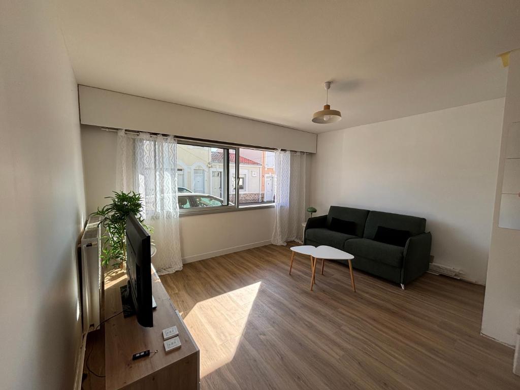 un salon avec un canapé et une télévision dans l'établissement Studio - bord de mer, à Les Sables-dʼOlonne