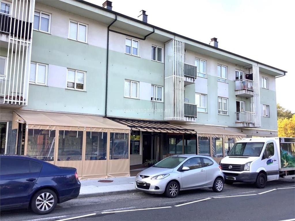 two cars parked in front of a building at Apartamento Rio Gallo II in Cuntis