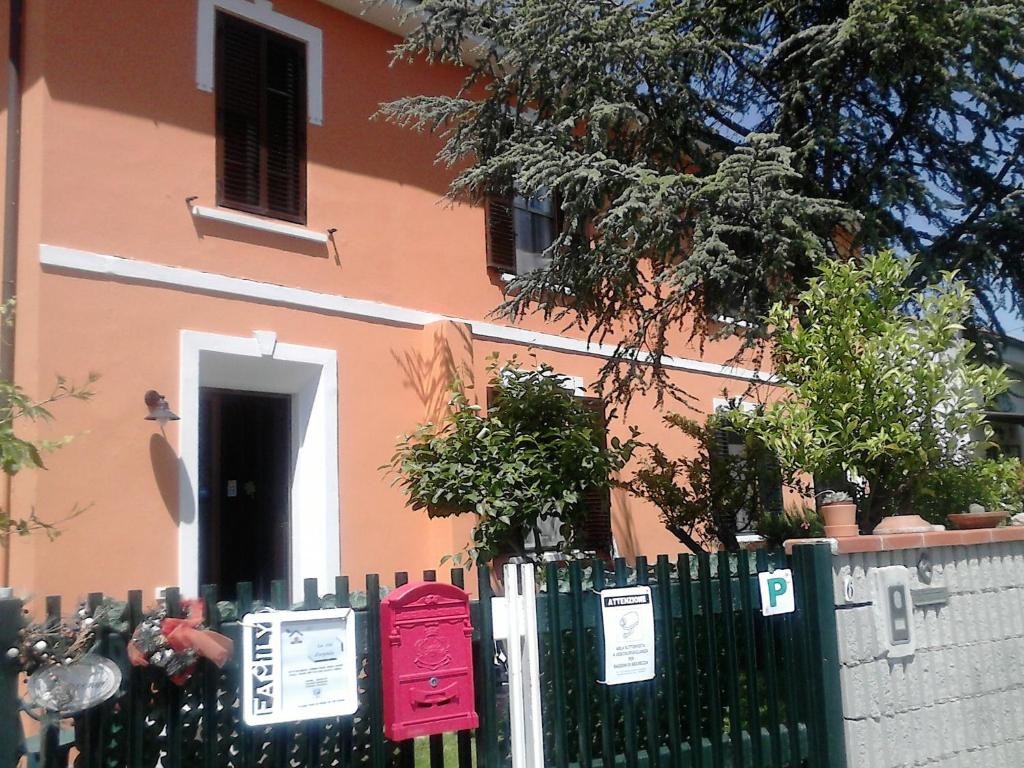 a fence in front of a house with a building at Le Ciel d'Orphèe in Pisa