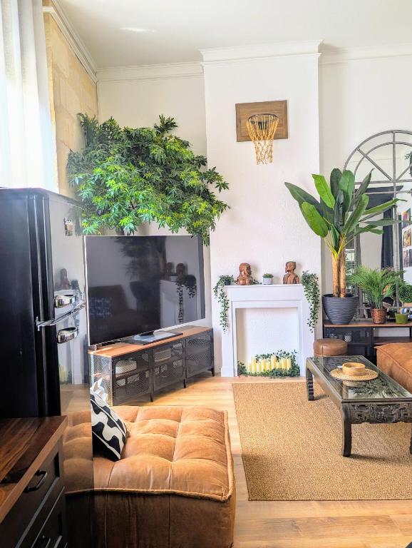 un salon avec un canapé et une télévision dans l'établissement Appartement cosy au coeur du centre historique de Bordeaux, à Bordeaux
