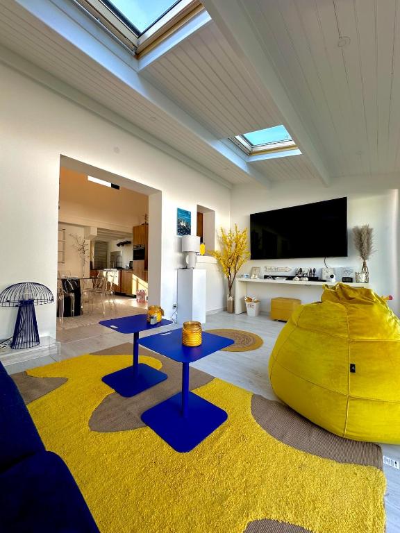 - un salon avec deux tables et une télévision dans l'établissement La Villa Delphine, à Vaux-sur-Mer